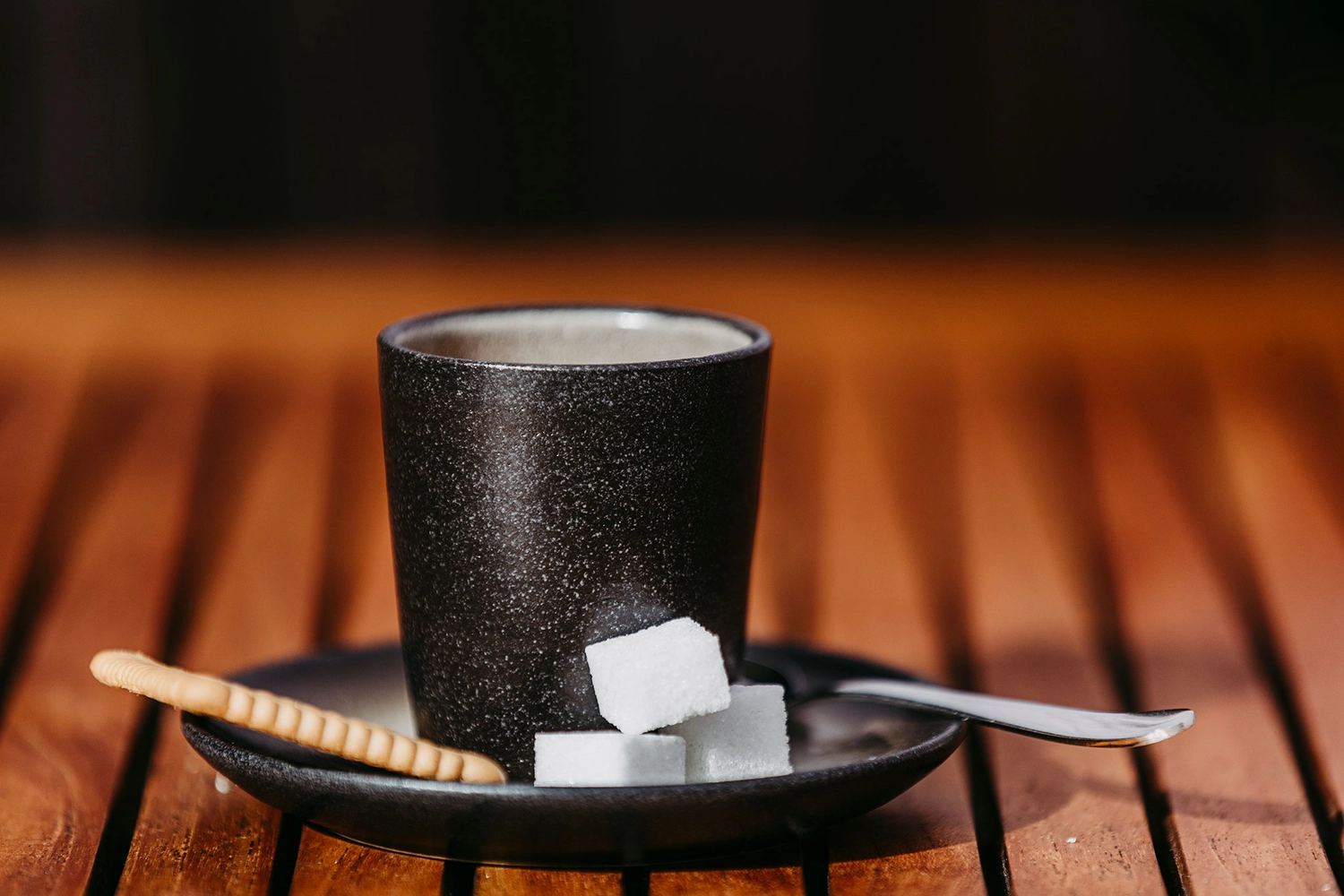 Keramik Atelier Melis - Töpferkurse - Dunkle Keramiktasse mit Zuckerwürfeln.