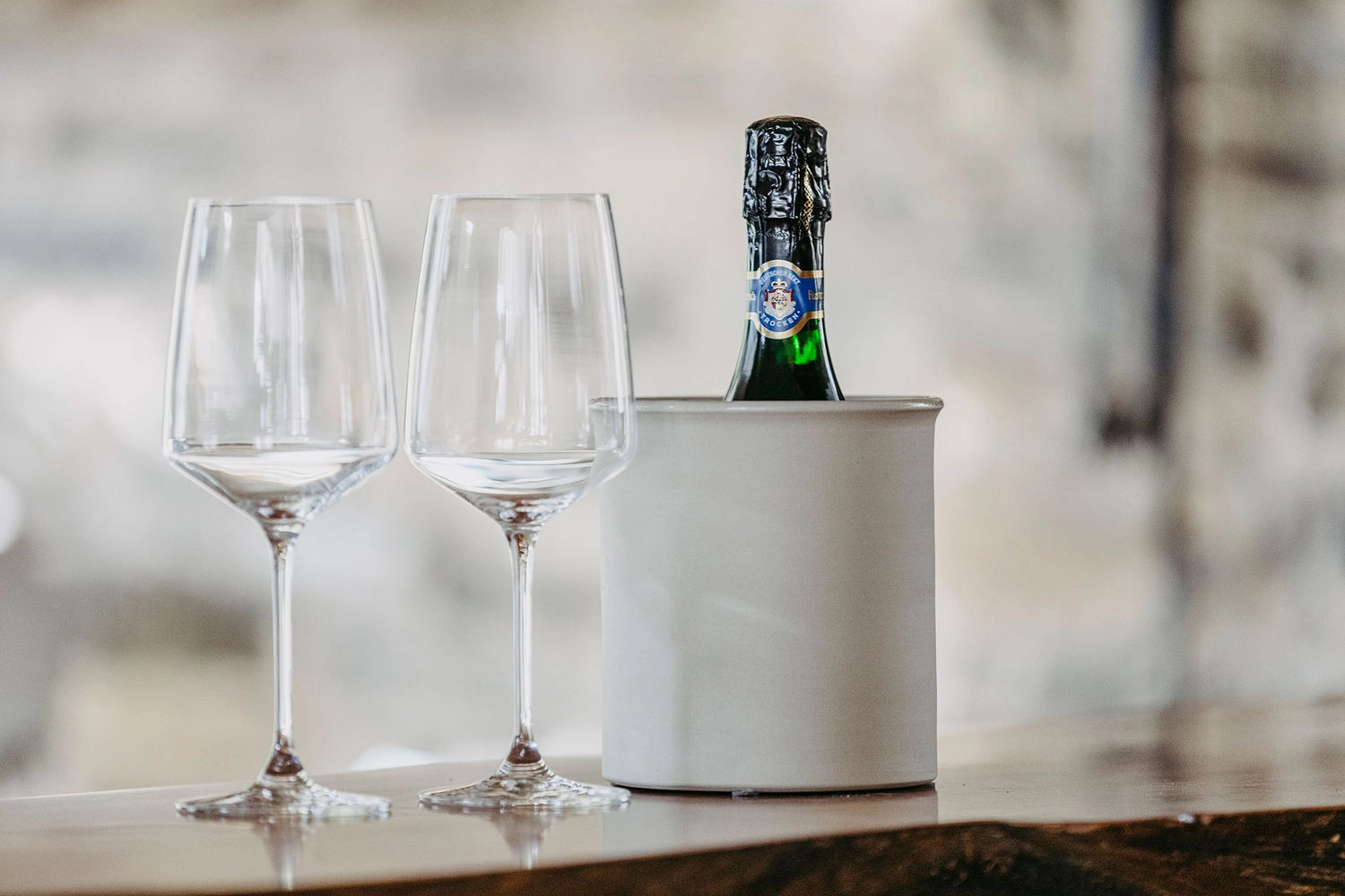 Keramik Atelier Melis - Töpferkurse - Eine Flasche Sekt in einem weißen Eisbehälter und zwei leere Gläser.