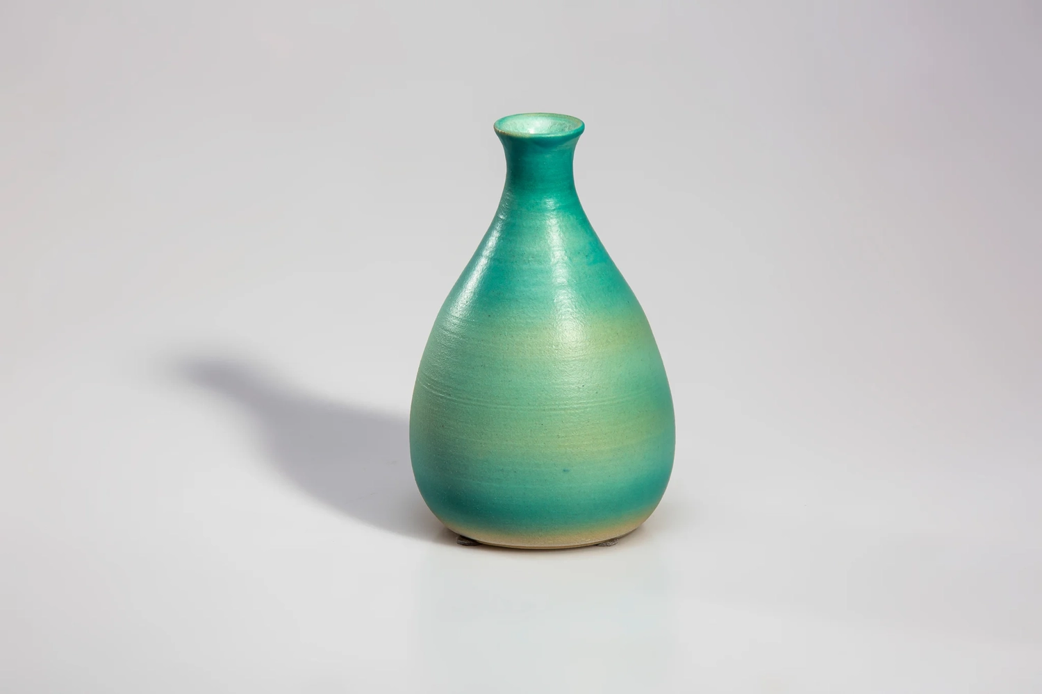 Keramik Atelier Melis - Töpferkurse - Eine Fotografie einer glasierten Porzellanvase, möglicherweise einer Tokkuri, mit rundem Korpus und schmalem Hals.