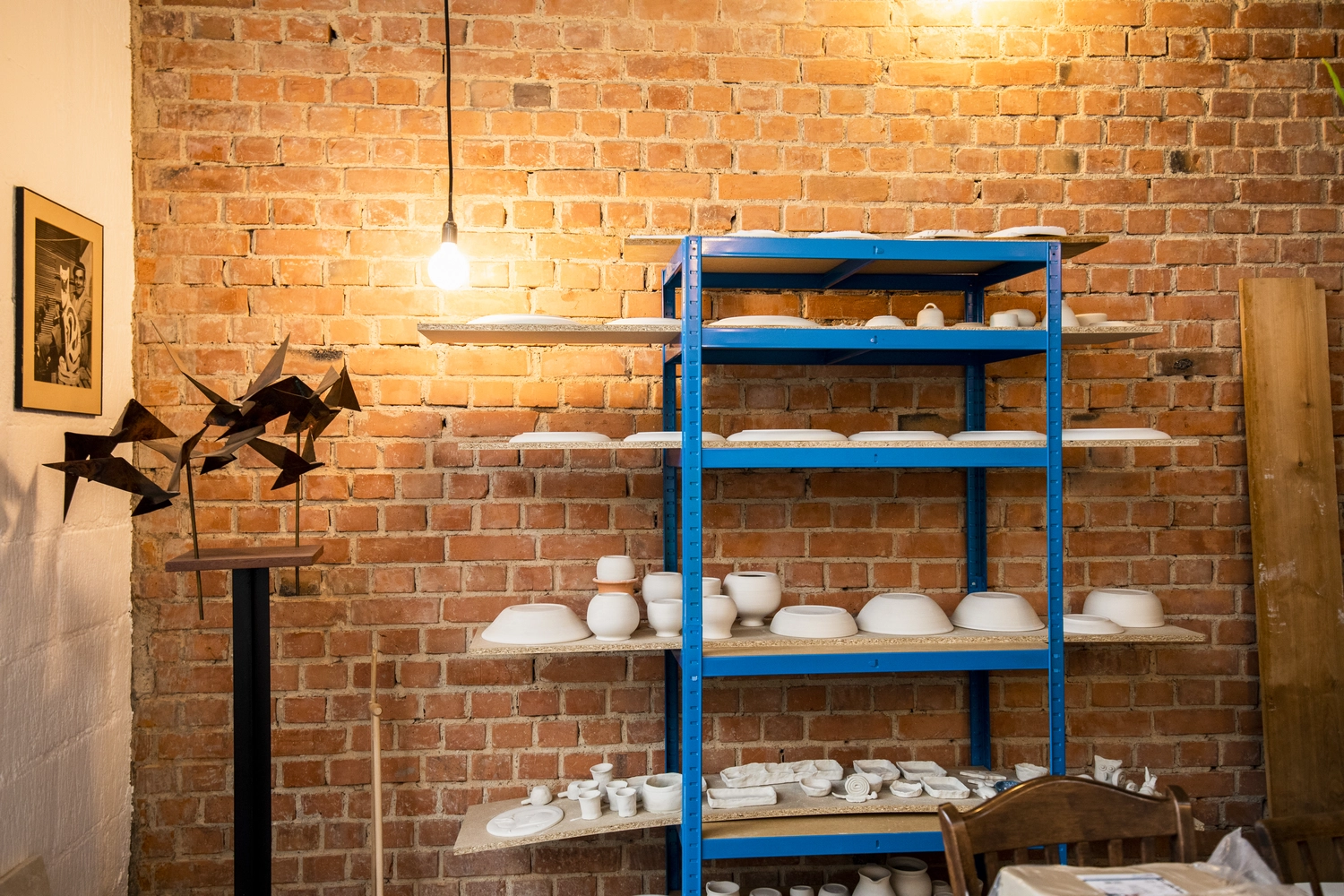 Keramik Atelier Melis - Töpferkurse - Innenansicht eines Töpferateliers mit einer roten Backsteinwand.