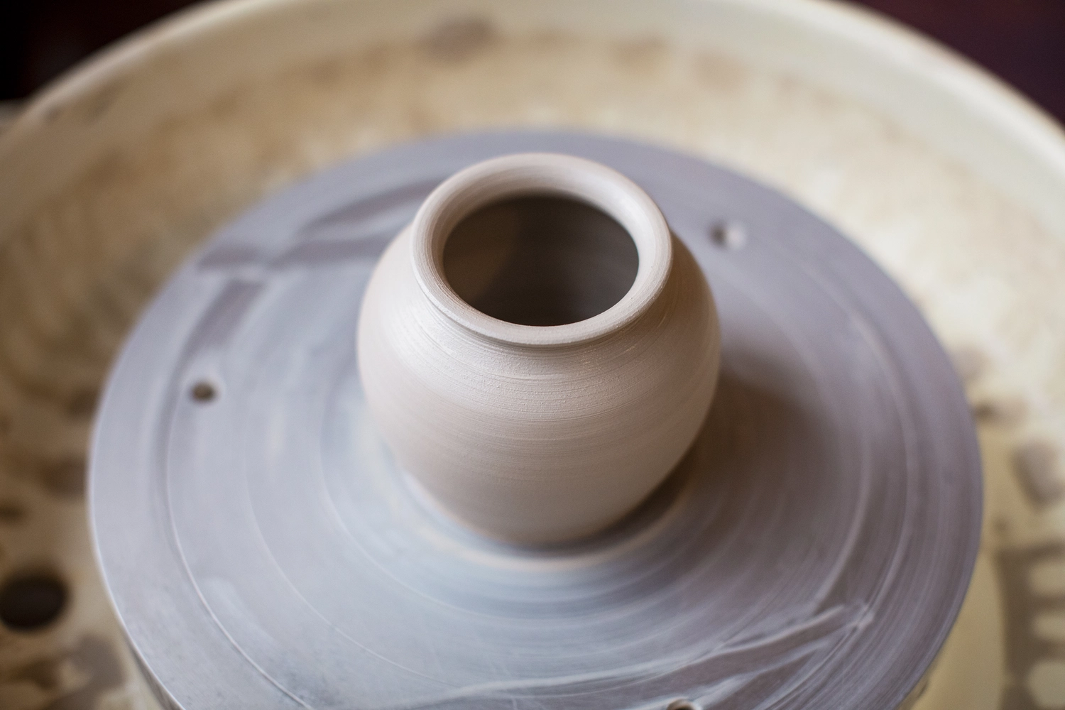 Keramik Atelier Melis - Töpferkurse - Dies ist ein kleiner, unfertiger Tontopf, der auf einer Töpferscheibe geformt wird.